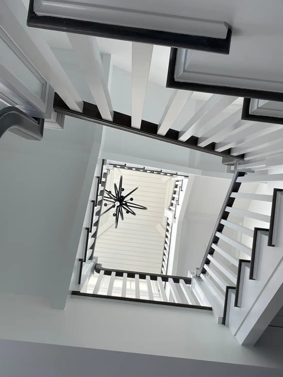 bottom of stairwell looking up at chandelier